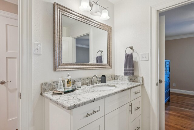 4222 Laren Ln, Dallas, TX 75244 - bathroom featuring wood finished floors, crown molding, vanity, and baseboards