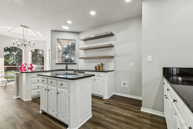 2111 Rheims Dr, Carrollton, TX 75006 - kitchen featuring a chandelier, a kitchen island, decorative backsplash, baseboards, and white cabinetry