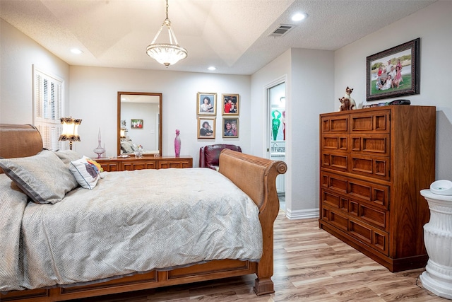 4728 Misty Oak Ln, Arlington, TX 76017 - bedroom featuring light wood finished floors, recessed lighting, a textured ceiling, and ensuite bath