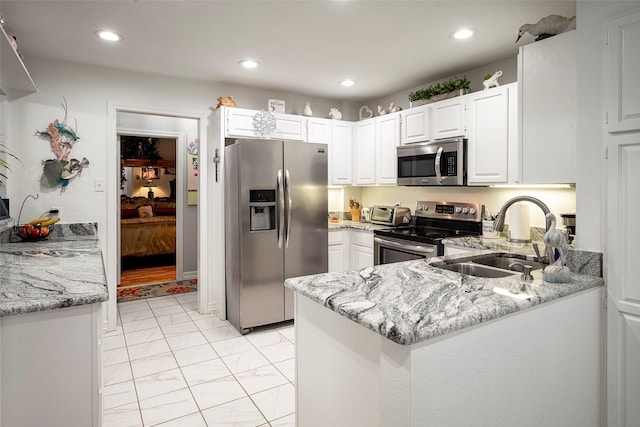 4728 Misty Oak Ln, Arlington, TX 76017 - kitchen with appliances with stainless steel finishes, a sink, light stone countertops, recessed lighting, and white cabinets