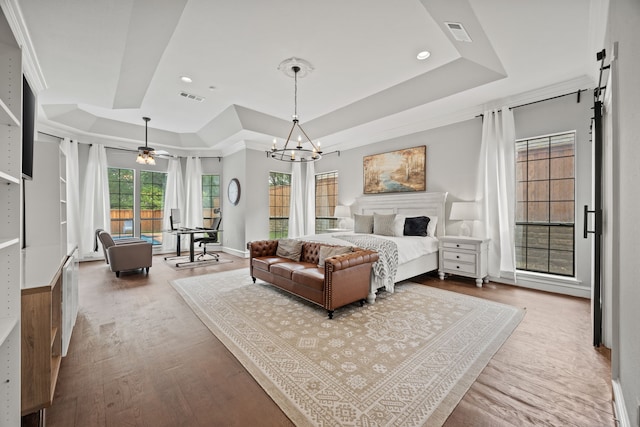 2320 Table Rock Ct, Arlington, TX 76006 - bedroom featuring a raised ceiling, wood finished floors, a barn door, a chandelier, and recessed lighting