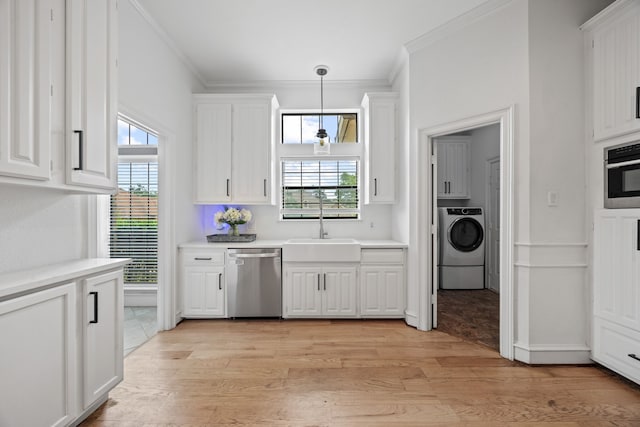 2320 Table Rock Ct, Arlington, TX 76006 - kitchen featuring stainless steel appliances, washer / clothes dryer, a sink, crown molding, and white cabinets