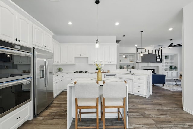 1601 Wheatberry Ct, Allen, TX 75002 - kitchen featuring stainless steel appliances, a sink, a peninsula, ceiling fan, and white cabinets