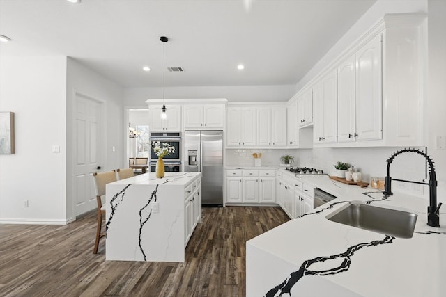 1601 Wheatberry Ct, Allen, TX 75002 - kitchen featuring stainless steel appliances, a sink, dark wood-style flooring, white cabinets, and recessed lighting