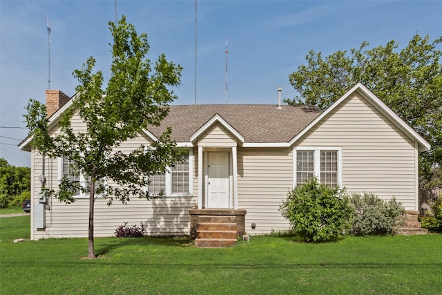 view of front of property featuring a chimney, a front lawn, and a shingled roof