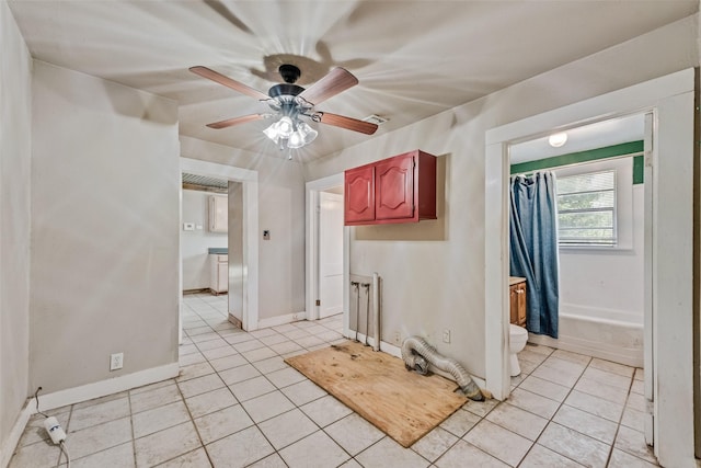unfurnished room with light tile patterned floors, a ceiling fan, and baseboards