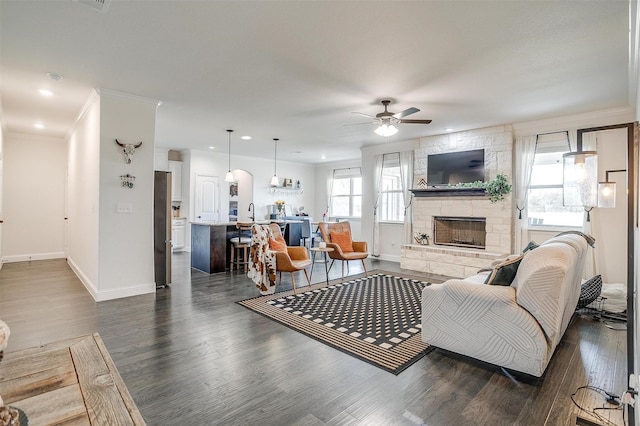 340 Sanger Dr, Springtown, TX 76082 - living area featuring a ceiling fan, baseboards, a fireplace, dark wood-type flooring, and crown molding