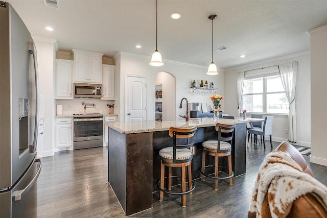 340 Sanger Dr, Springtown, TX 76082 - kitchen with appliances with stainless steel finishes, arched walkways, ornamental molding, white cabinetry, and a breakfast bar area