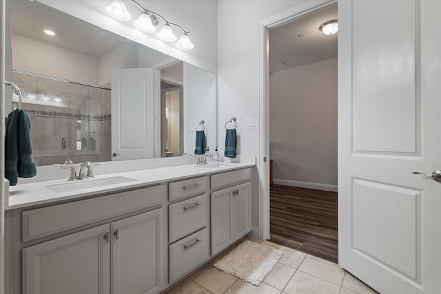5542 Yellowstone Rd, The Colony, TX 75056 - bathroom with tile patterned flooring, double vanity, a tile shower, and baseboards