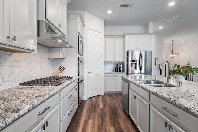 5542 Yellowstone Rd, The Colony, TX 75056 - kitchen featuring appliances with stainless steel finishes, a sink, under cabinet range hood, dark wood finished floors, and backsplash