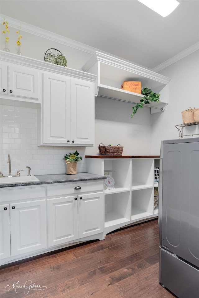 152 Sand Beach Blvd, Shreveport, LA 71105 - washroom with crown molding, washer / clothes dryer, dark wood-style flooring, and cabinet space