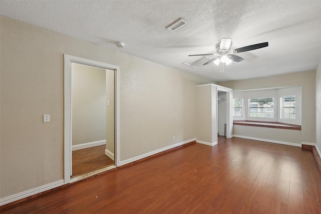 5605 Santa Fe Trl, Haltom City, TX 76148 - spare room featuring ceiling fan, wood finished floors, baseboards, a textured ceiling, and a textured wall