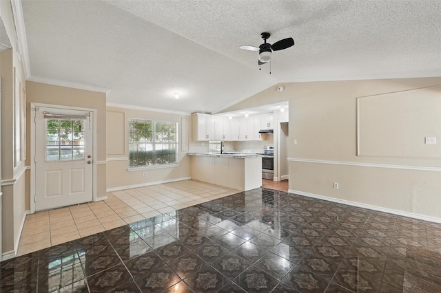 5605 Santa Fe Trl, Haltom City, TX 76148 - kitchen featuring tile patterned floors, ceiling fan, a peninsula, vaulted ceiling, and stainless steel range with electric cooktop