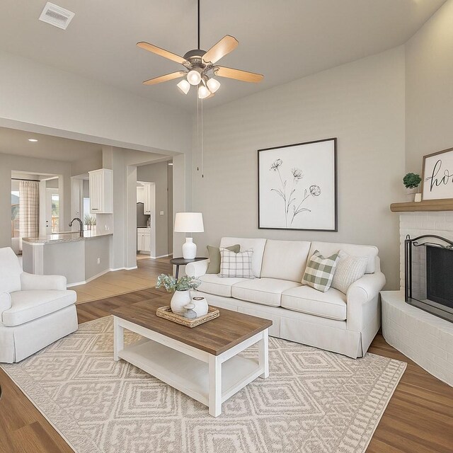 1212 Wheatear, Little Elm, TX 75068 - living room with wood finished floors, ceiling fan, and a fireplace