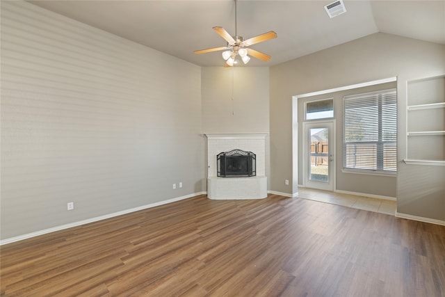 1212 Wheatear, Little Elm, TX 75068 - unfurnished living room with ceiling fan, wood finished floors, a brick fireplace, baseboards, and vaulted ceiling