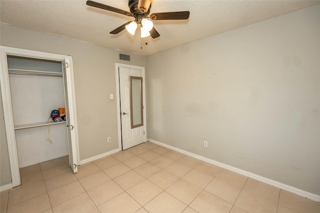 97 Wade St, Nocona, TX 76255 - unfurnished bedroom with a textured ceiling, baseboards, light tile patterned flooring, a closet, and a ceiling fan