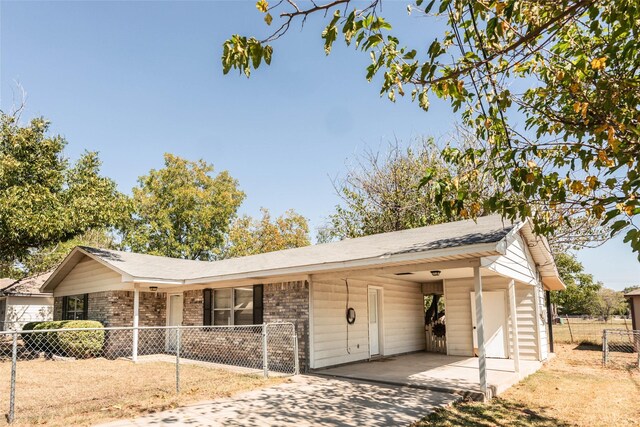 97 Wade St, Nocona, TX 76255 - view of front of property with fence, an attached carport, driveway, and brick siding