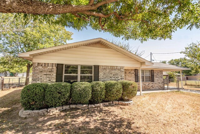 97 Wade St, Nocona, TX 76255 - single story home featuring brick siding, a gate, fence, and an attached carport