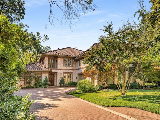 6302 Waggoner Dr, Dallas, TX 75230 - mediterranean / spanish home with a tiled roof, a front yard, decorative driveway, and brick siding