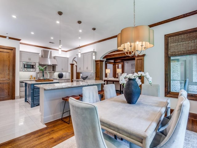 6302 Waggoner Dr, Dallas, TX 75230 - dining space with a chandelier, crown molding, arched walkways, recessed lighting, and light wood-type flooring