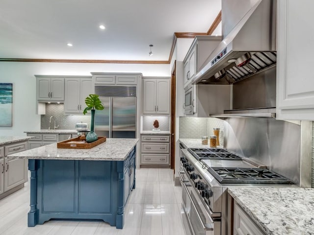 6302 Waggoner Dr, Dallas, TX 75230 - kitchen featuring high quality appliances, wall chimney range hood, crown molding, backsplash, and blue cabinets