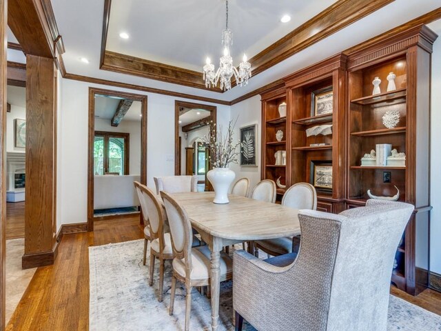 6302 Waggoner Dr, Dallas, TX 75230 - dining space featuring ornamental molding, a chandelier, wood finished floors, baseboards, and a tray ceiling