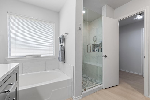 1930 Copper Ridge Cir, Rockwall, TX 75032 - bathroom featuring wood finished floors, a garden tub, vanity, and a stall shower