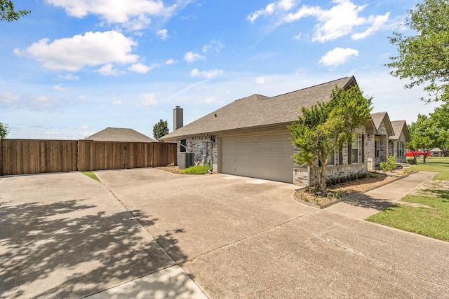 1930 Copper Ridge Cir, Rockwall, TX 75032 - view of side of property featuring concrete driveway, an attached garage, cooling unit, roof with shingles, and stone siding