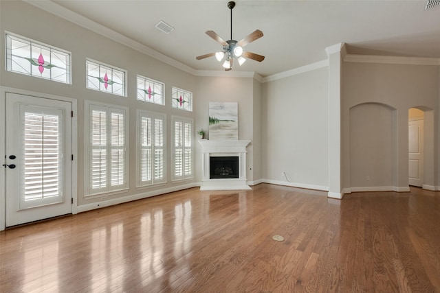 8621 Nichols Way N, Richland Hills, TX 76180 - unfurnished living room featuring ceiling fan, wood finished floors, ornamental molding, arched walkways, and a fireplace with raised hearth