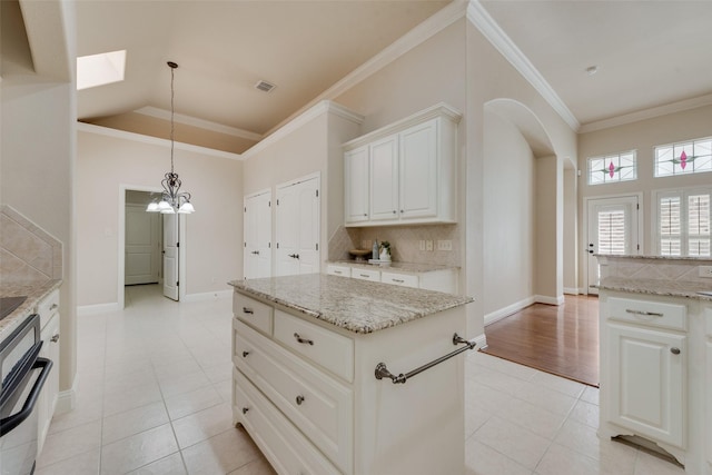 8621 Nichols Way N, Richland Hills, TX 76180 - kitchen with tasteful backsplash, arched walkways, light tile patterned floors, a skylight, and light stone countertops