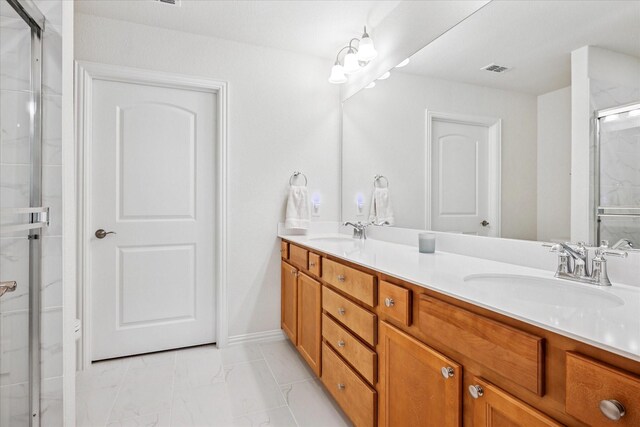 full bath with marble look tile flooring, a stall shower, and double vanity