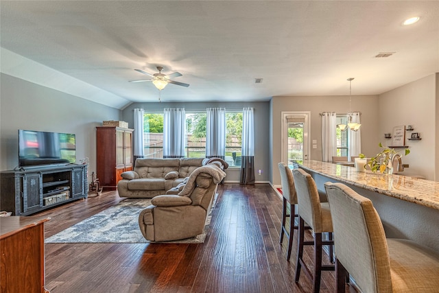living area with a ceiling fan, dark wood finished floors, recessed lighting, baseboards, and a chandelier