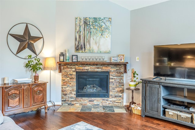 living room featuring wood finished floors, a fireplace, baseboards, and vaulted ceiling