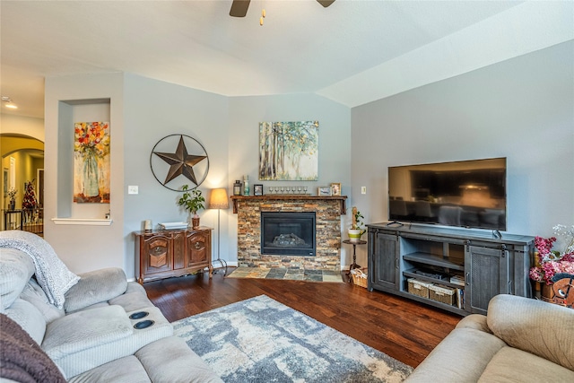 living room with arched walkways, a fireplace, wood finished floors, ceiling fan, and vaulted ceiling