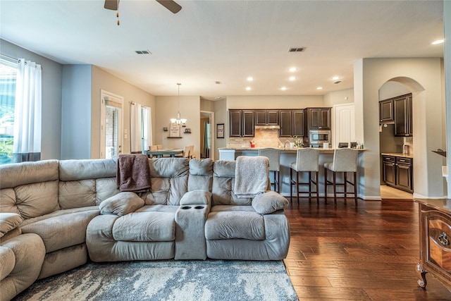 living area with hardwood / wood-style flooring, a chandelier, a ceiling fan, recessed lighting, and arched walkways