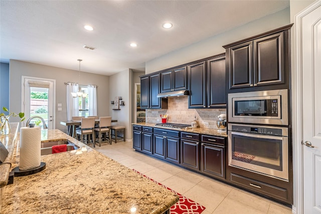 kitchen featuring appliances with stainless steel finishes, light tile patterned flooring, decorative backsplash, light stone countertops, and recessed lighting