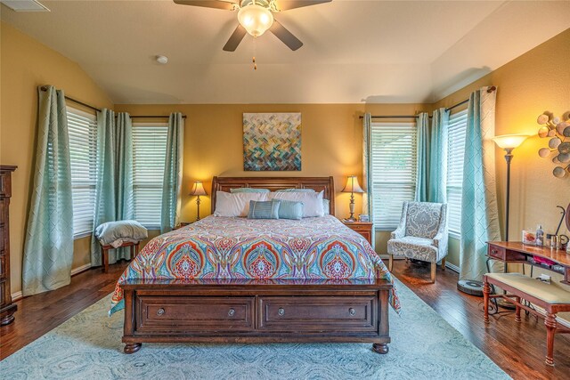 bedroom with multiple windows, wood finished floors, lofted ceiling, a ceiling fan, and baseboards
