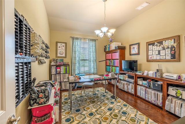 home office featuring a chandelier, vaulted ceiling, and wood finished floors