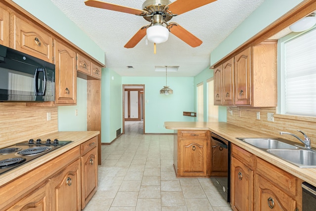 kitchen featuring a sink, black appliances, a peninsula, tasteful backsplash, and light countertops