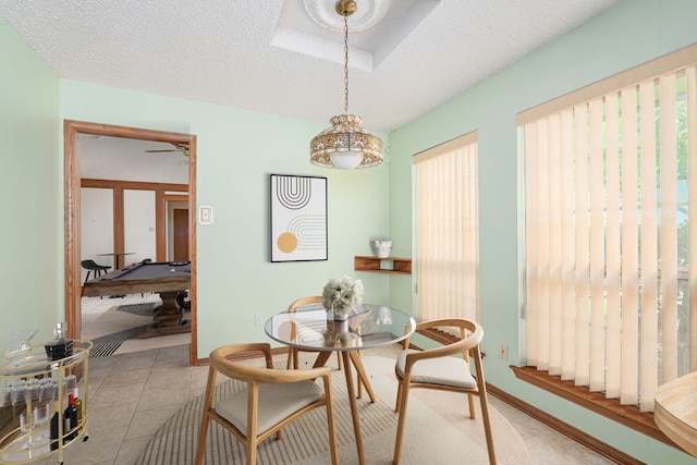 dining area featuring a textured ceiling and light tile patterned flooring