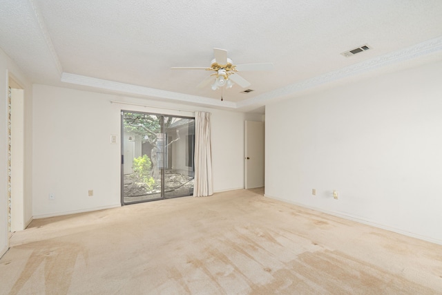 carpeted empty room with a tray ceiling, ceiling fan, and baseboards
