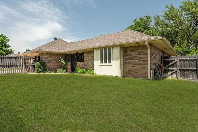 rear view of house featuring brick siding, roof with shingles, and a gate