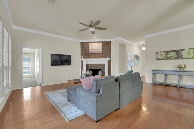1424 Greenwich Dr, Allen, TX 75013 - living room featuring a ceiling fan, wood finished floors, crown molding, a brick fireplace, and baseboards