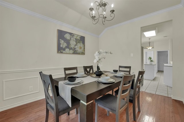 1424 Greenwich Dr, Allen, TX 75013 - dining area featuring a chandelier, wood-type flooring, crown molding, and a wainscoted wall