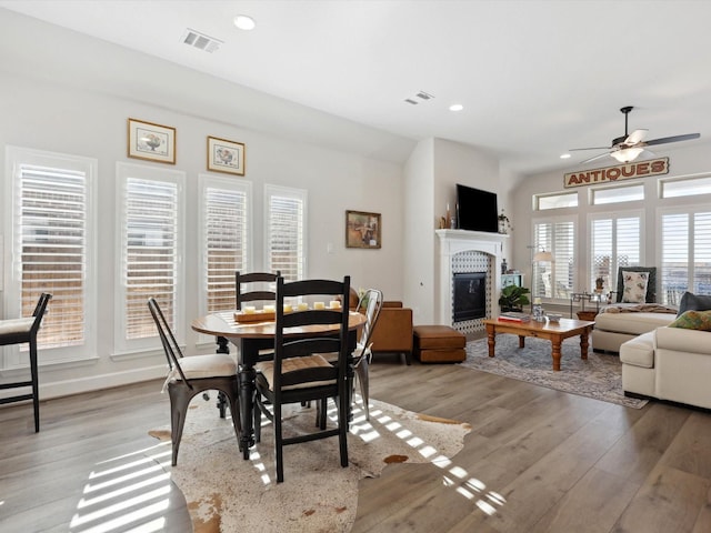 1227 Rushcroft Way, Forney, TX 75126 - dining room with a tiled fireplace, light wood-type flooring, a ceiling fan, and recessed lighting