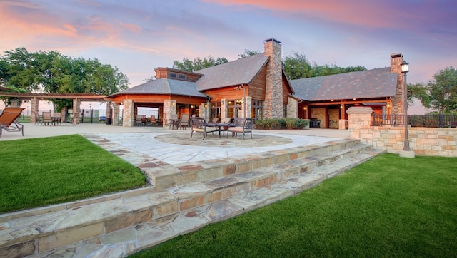 1227 Rushcroft Way, Forney, TX 75126 - back of property at dusk featuring a gazebo, a lawn, a patio area, stone siding, and a chimney