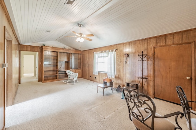 9820 County Road 514, Alvarado, TX 76009 - living area with wood walls, ceiling fan, vaulted ceiling, and light carpet