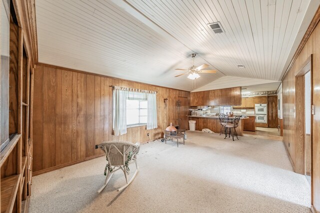 9820 County Road 514, Alvarado, TX 76009 - living area with wooden walls, vaulted ceiling, a ceiling fan, light carpet, and wooden ceiling