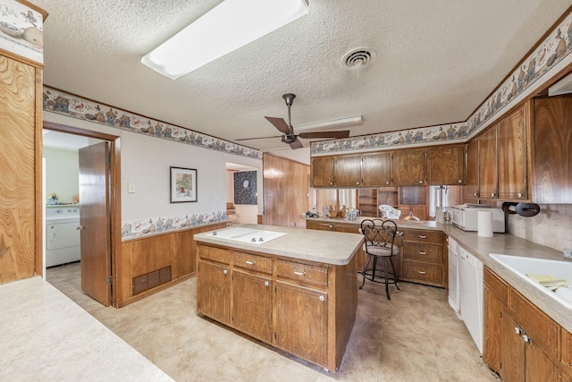 9820 County Road 514, Alvarado, TX 76009 - kitchen with a textured ceiling, ceiling fan, washer / dryer, wainscoting, and white appliances