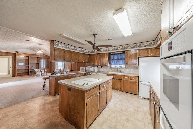 9820 County Road 514, Alvarado, TX 76009 - kitchen featuring a ceiling fan, a sink, vaulted ceiling, light countertops, and a center island
